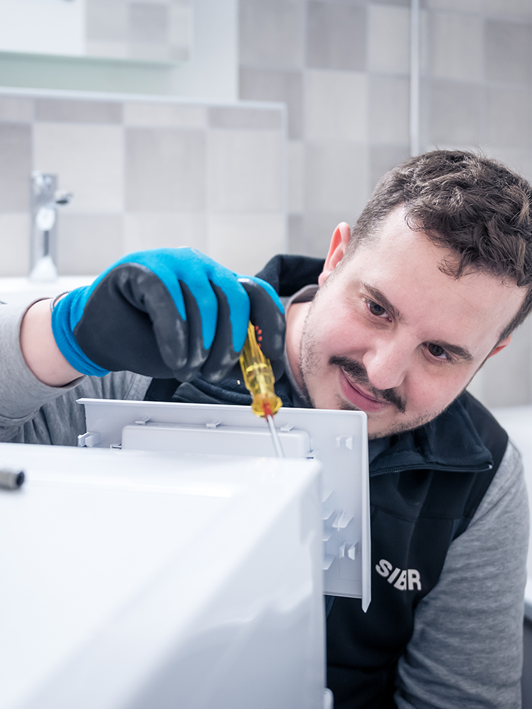 SIBIR Techniker repariert Waschmaschine